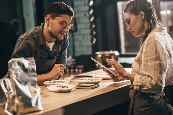 Mujer Enfocada Utilizando Tableta Con Joven Colega Cerca Cafetería — Foto de Stock