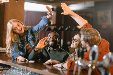 Genç arkadaşlar birbirlerine beşlik veren Bar