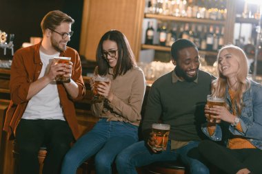 cheerful multiculture friends drinking beer together at bar   clipart