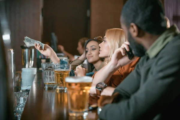 Menina Bonita Com Dinheiro Pagando Para Beber Bar Com Amigos — Fotografia de Stock