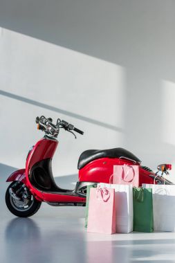 Kırmızı vintage scooter ve görücü usulü alışveriş torbaları