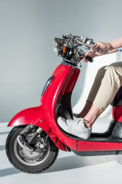 Kısmi görünümü şık giyim kırmızı scooter üzerinde oturan adamın
