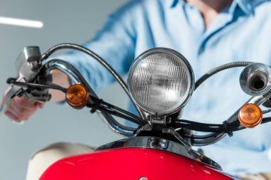 Kısmi görünümü şık giyim kırmızı scooter üzerinde oturan adamın