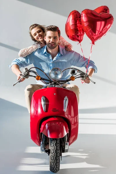Sorrindo Jovem Casal Com Balões Forma Coração Vermelho Equitação Scooter — Fotografia de Stock