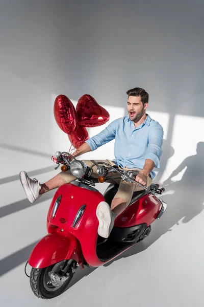 Jeune Homme Avec Des Ballons Forme Coeur Équitation Scooter Rouge — Photo