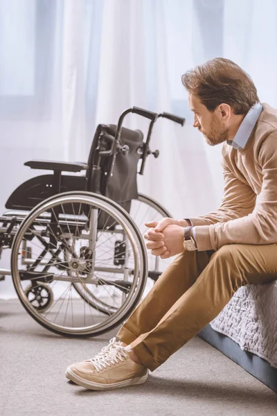 Worried Man Disability Sitting Bed Looking Wheelchair — Stock Photo, Image