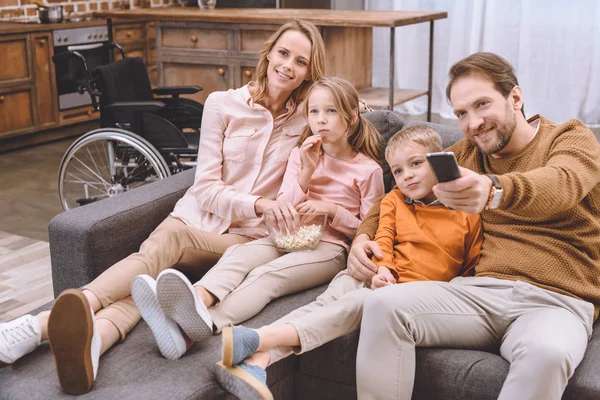 Família Feliz Sentado Sofá Assistindo Juntos Cadeira Rodas Atrás — Fotografia de Stock