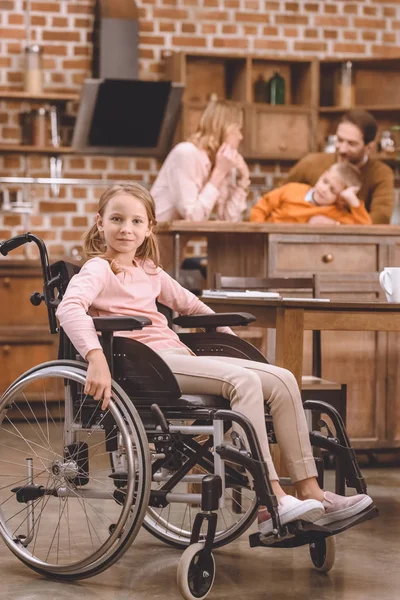 Ładna Dziewczynka Wózku Inwalidzkim Patrząc Kamery Podczas Gdy Inni Członkowie — Zdjęcie stockowe