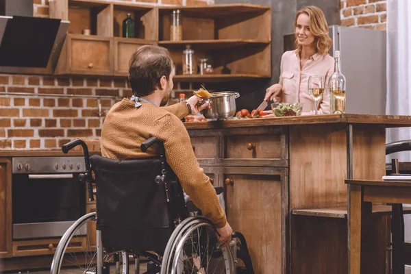 Mujer Sonriente Con Hombre Silla Ruedas Cocinando Cena Juntos Casa — Foto de Stock