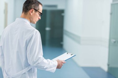 Hastanede tanı okuma beyaz ceket erkek doktor