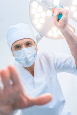 bir hastada ameliyat odası yukarıda duran ve kameraya bakarak doktor alttan görünüm