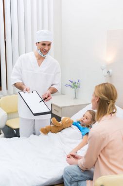 panoya işaret ve anne ve kızı ile konuşurken doktor gülümseyen