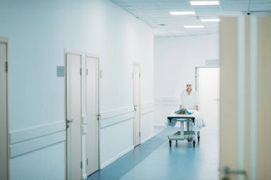 Doktor koridorda tıbbi sedye üzerinde okul öncesi hasta taşıma 