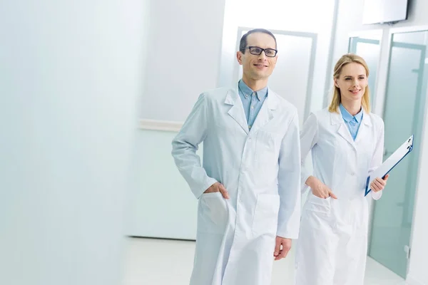 Médicos Sonrientes Con Batas Blancas Con Diagnóstico Pasillo Del Hospital — Foto de Stock