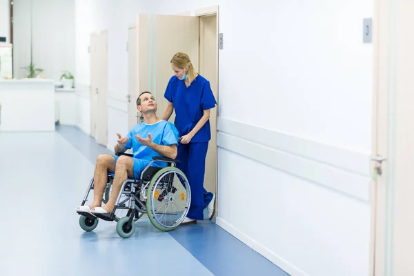 Chirurgien Parlant Avec Patient Masculin Fauteuil Roulant Dans Couloir Hôpital — Photo