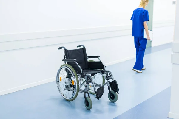 病院の廊下 フォア グラウンドで車椅子の女性外科医  — 無料ストックフォト
