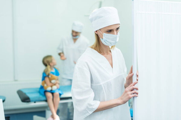 doctors preparing kid for surgery in operating room