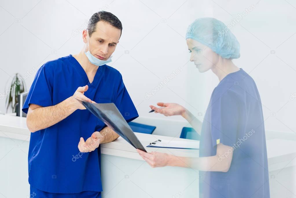 two surgeons discussing x-ray and diagnosis in hospital
