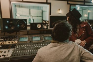 sound producers looking at singer at recording studio clipart
