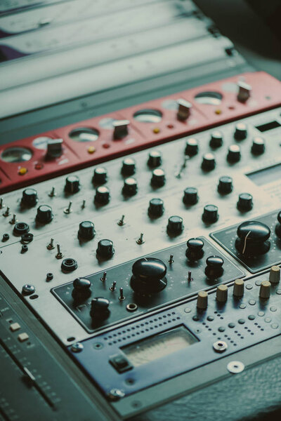 close-up shot of graphic equalizer with various knobs at recording studio