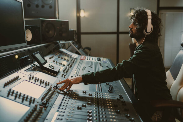side view of concentrated sound producer working at studio