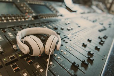 close-up shot of headphones on graphic equalizer at recording studio clipart