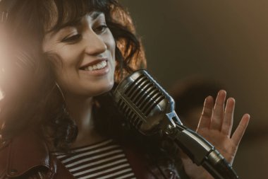 attractive young female singer performing song and smiling