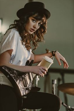 güzel kadın müzisyen elektro gitar ve kahve ile kameraya aramaya