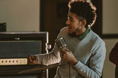 yakışıklı Afro-Amerikan şarkıcı şarkı mikrofon ile performans