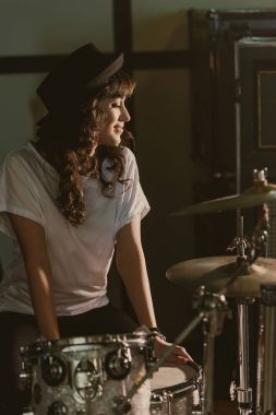 beautiful female drummer sitting at drum set clipart