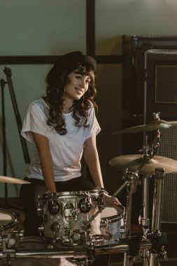 attractive female drummer sitting at drum set clipart