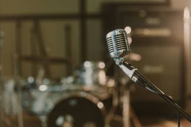 close-up shot of vintage microphone on stand against blurred drum set clipart