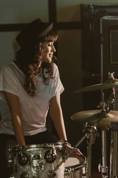 beautiful female drummer sitting at drum set