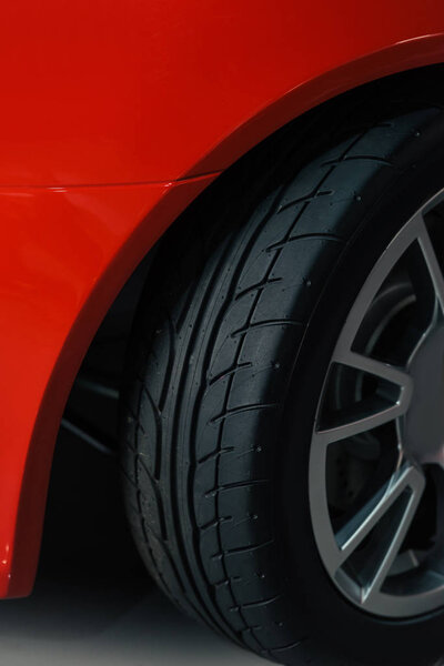 cropped shot of wheel of red sport car