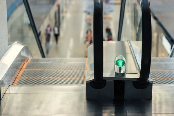 close-up shot of green light of escalator at shopping mall