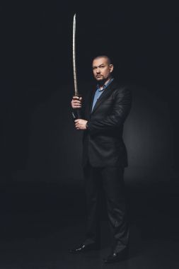 siyah Japon katana kılıcı ile takım elbiseli ciddi adam