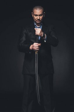 siyah Japon katana kılıcı ile takım elbiseli adam