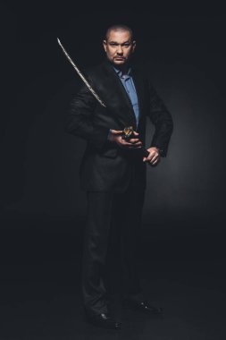 siyah Japon katana kılıcı ile takım elbiseli olgun adam