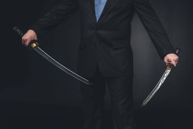 crppped shot of man in suit with dual katana swords on black clipart