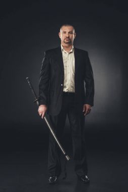 siyah katana ile takım elbiseli olgun yakışıklı adam