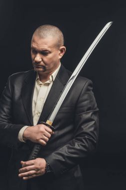 siyah izole katana kılıcı ile takım elbiseli adam