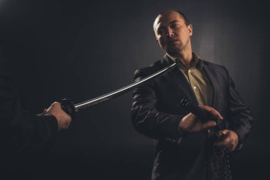 yakuza üye gitting kılıcını yaptırmayı siyah izole iken boyun katana ile dürttü