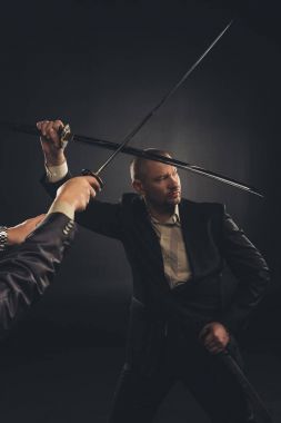 güçlü olgun işadamı siyah izole katana kılıcı ile mücadele