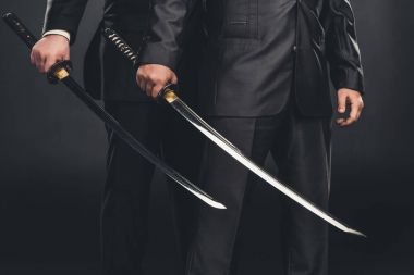 cropped shot of modern samurai with katana swords isolated on black clipart