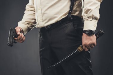 cropped shot of yakuza member with tanto knife and gun clipart