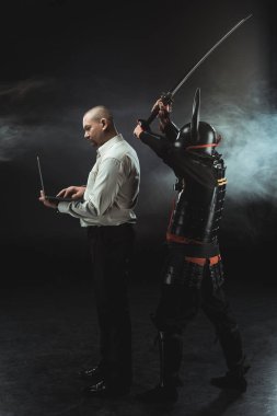 man using laptop while samurai making hit with sword clipart