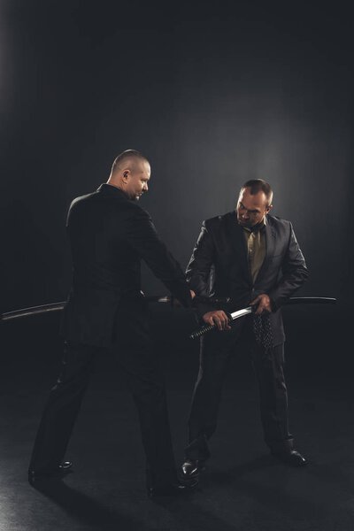 businessmen taking out katana swords for fight isolated on black