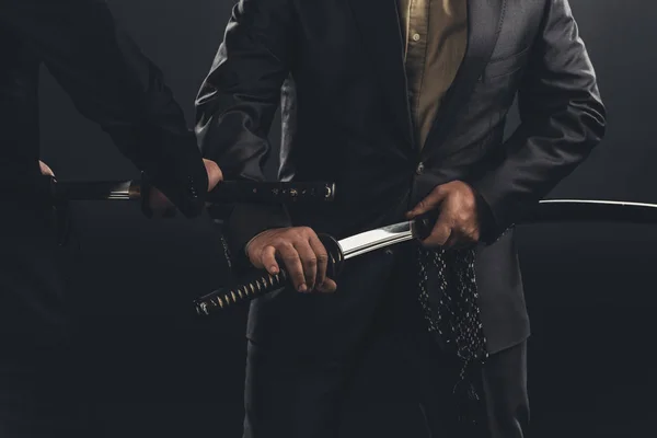 stock image cropped shot of modern samurai taking out their swords isolated on black