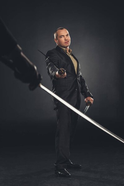 modern samurai in suit ready to fight on black