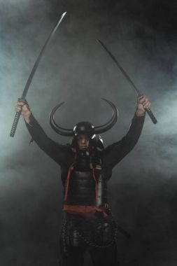 Samuray zırh duman ile koyu arka plan üzerinde çift katana kılıçlı